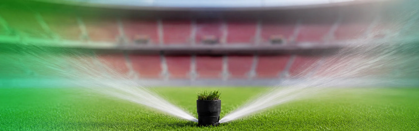 Multistage pumps shown with irrigation sprinklers watering green sports turf.